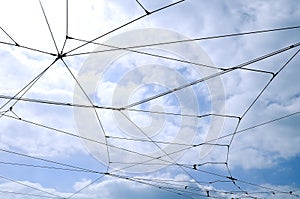 Trolleybus wires against a blue sky with white clouds