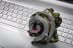 Trolling and cyber bullying concept with a troll sitting on a laptop`s keyboard. Cyberbullying in one of the major issues