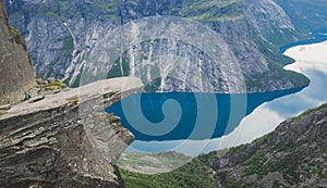 Trolltunga - famous rock formation and tourist famous hike, beautiful norwegian summer landscape with fjord, mountain and lake