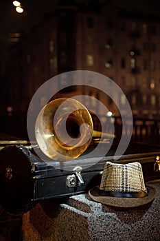 Trombone, men`s hat and night city