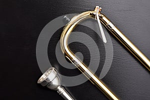 Trombone slide with water key detail and mouthpiece on table