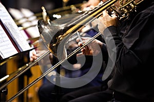 Trombones in the hands of musicians in the orchestra
