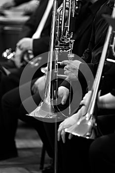 Trombones in the hands of the musicians in the orchestra