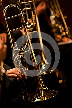 The trombones in the hands of the musicians on the stage