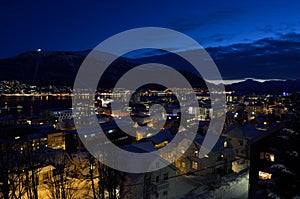 Tromso city at winter snowy night with light,traffic,fjord and motion with mainland