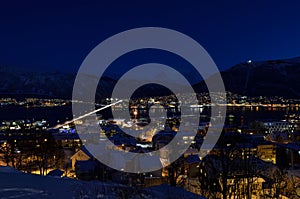 Tromso city at winter snowy night with light,traffic,fjord and motion with mainland