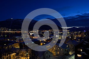 Tromso city at winter snowy night with light,traffic,fjord and motion with mainland