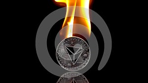 Tron - TRX coin catches fire on an isolated black background. Slow motion 250fps.