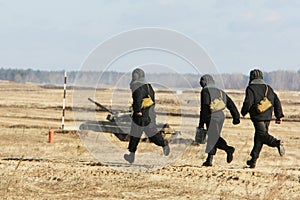 Troopers run to a tank