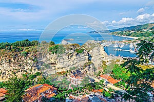 Tropea town aerial view of port marina, stone rocks and cliffs and Tyrrhenian sea with turquoise water