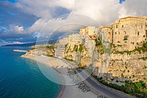 Tropea town and Tyrrhenian Sea beach, colorful buildings on top of high big steep rock cliff, view from Sanctuary church of Santa