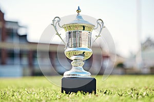 Trophy on grass, champion and award with fitness outdoor, competition and game with mockup space. Prize on pitch, reward