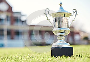 Trophy on grass, champion and prize with fitness outdoor, competition and game with mockup space. Award on pitch, reward