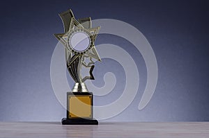 Trophy placed on wooden table over dark background