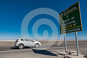 Tropic of Capricorn sign and blurred car in Atacama Desert, Chile - South America