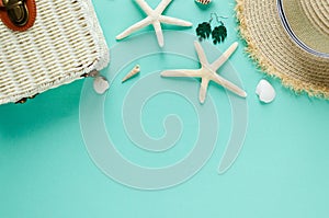 Tropic flat lay with straw hat, bag, starfish, shells, sunglasses, boat, earrings on green background. Summer fashion flat lay