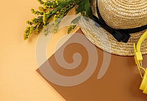 Tropic leaves, straw hat on brown background. Trendy fashion accessories. Flat lay, close up. Summer, vacation, holidays concept
