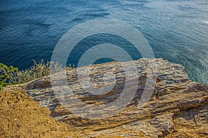 Tropic vivid colorful mountain rocks and blue green water surface with waves from above in warm colorful summer day weather