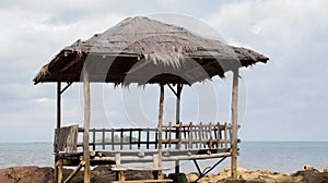 Tropical asian beach hut natural wooden handmade and thatch roof on the rocky shore