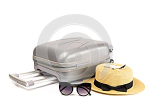 Tropical background. Suitcase, sunglasses with toy plane and straw hat in travel composition isolated on white background. Exotic