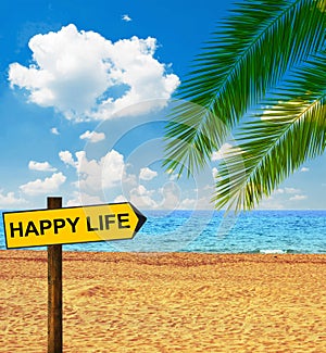 Tropical beach and direction board saying HAPPY LIFE