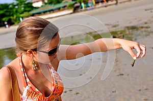 Tropical beach, finding a shell in Krabi, Thailand