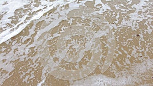 Tropical beach, foamy ocean waves washing sand. Waves hitting sand beach