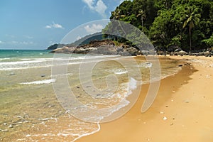 Tropical beach with golden sand, frequent clear water with waves