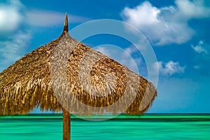 Thatched beach cabana on sunny beach photo