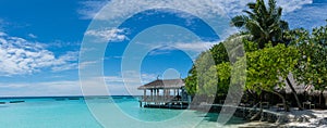 Tropical beach island panorama with hut at Maldives