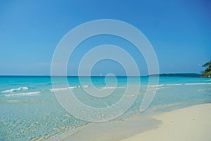 Tropical beach at Koh Kood, Thailand. turquoise sea water, ocean wave, yellow sand, green palms, sun blue sky, white clouds,