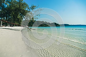 Tropical beach at Koh Kood, Thailand. turquoise sea water, ocean wave, yellow sand, green palms, sun blue sky, white clouds,