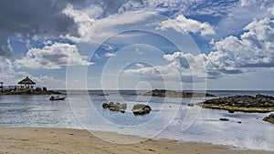 Tropical beach at low tide. Exposed rocks protrude from the water. photo