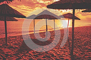 Tropical beach scenery with sun parasols. Straw sun umbrellas on the beach