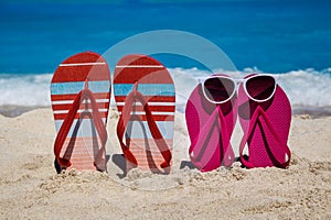 Tropical beach in the summer with flip flops in the sand and sun