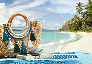 Tropical beach summer holiday accessories, with blurred beach palm trees and sea in background.