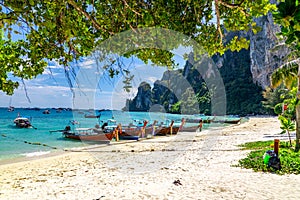 Tropical beach. Summer vacation getaway concept. Traditional wooden boats parked at a beach in Phi Phi Islands, Thailand
