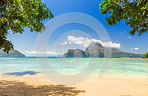 Tropical beach with lush green islands in the backgroud
