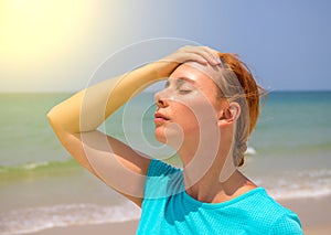 Tropical beach sun threat for health. Woman on hot beach with sunstroke. Health problem on holiday.