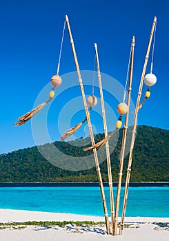 Tropical beach with turquoise clear sea and buoys on bamboo sticks decoration