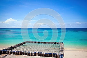 Tropical beach with turquoise water and photo spot with hammock