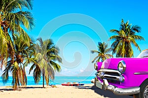 The tropical beach of Varadero in Cuba with american classic pink car, sailboats and palm trees on a summer day with turquoise