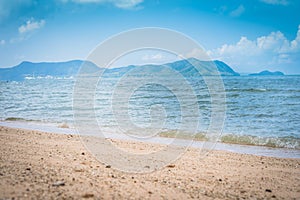 Tropical beach view. Calm and relaxing empty beach scene, blue sky and white sand. Tranquil nature concept.