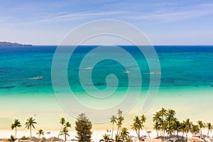 Tropical beach with white sand and palm trees, view from above. Turquoise lagoon with a sandy bottom