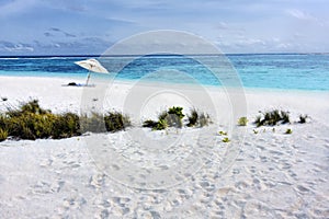 Tropical beach with white sand and sun umbrella in Maldivi photo