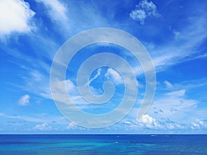 Tropical blue sky background with white cloud trails over caribbean sea. Soft white clouds in blue sky of the Caribbean. Textures