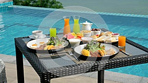 Tropical breakfast with fresh fruit by swimming pool on terrace with sea view