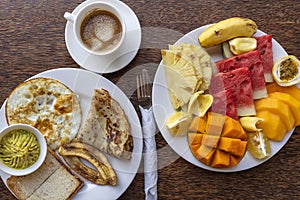 Tropical breakfast of fruit, coffee and scrambled eggs and banana pancake