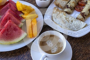 Tropical breakfast of fruit, coffee and scrambled eggs and banana pancake