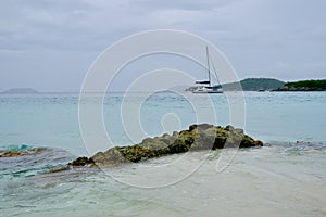 Tropical Caribbean Seascape With Sailboat and Rocky Shore